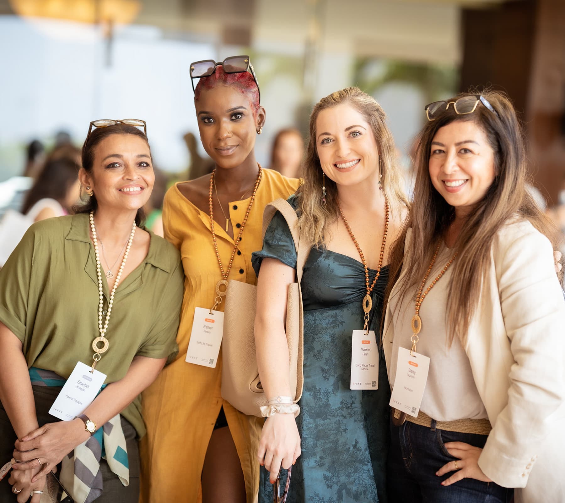 Four smiling attendees wearing TFest lanyards