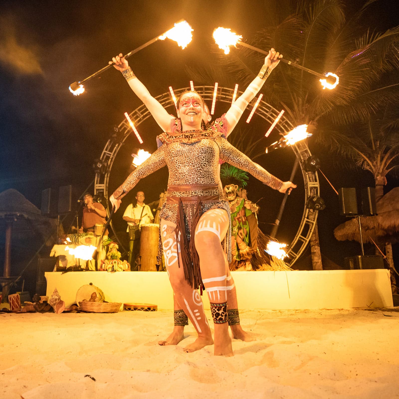 A fire dancer performing on the beach at night