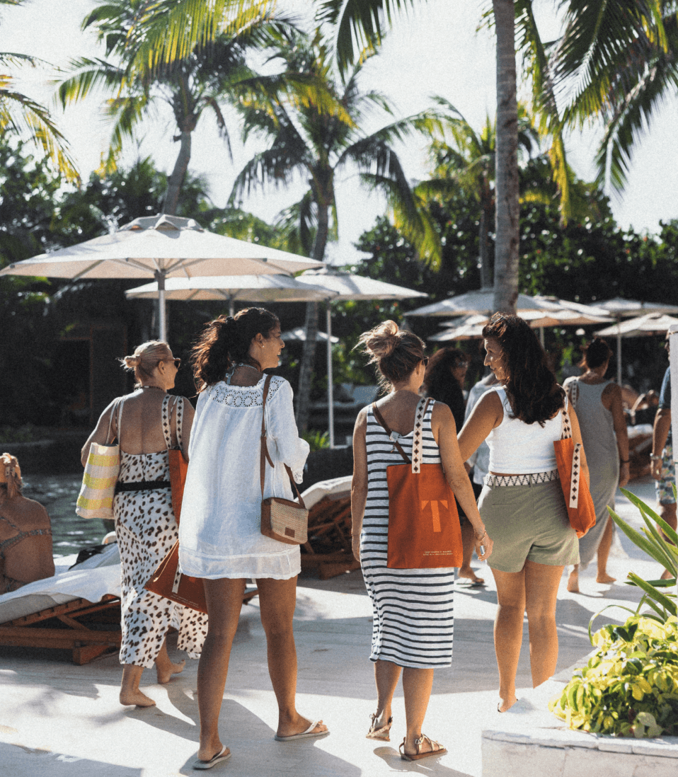 Attendees with TFest tote bags walking through the resort
