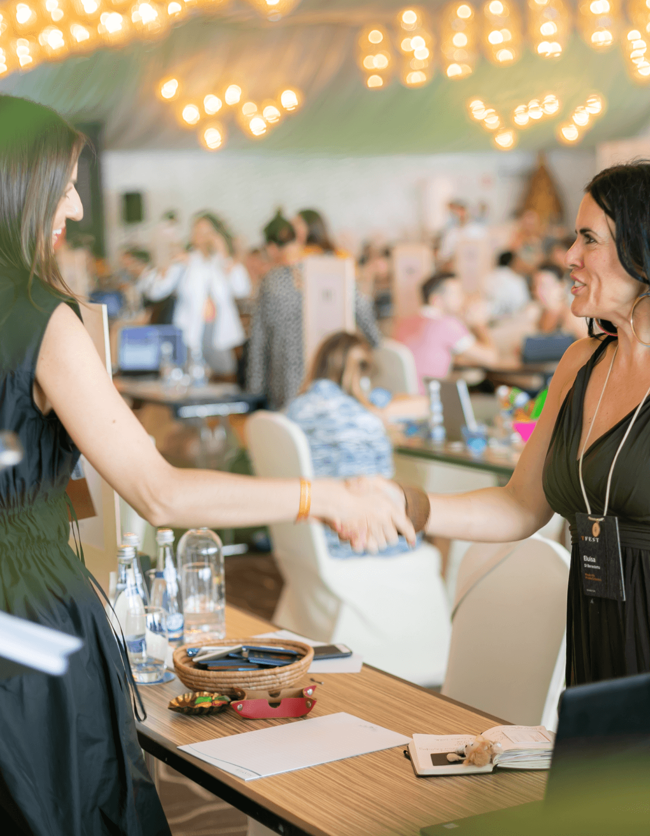 Two attendees shaking hands at a TFest meeting table