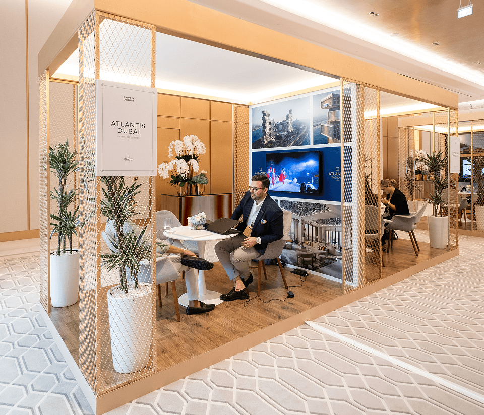 A branded Showcase Studio booth with seating and screens